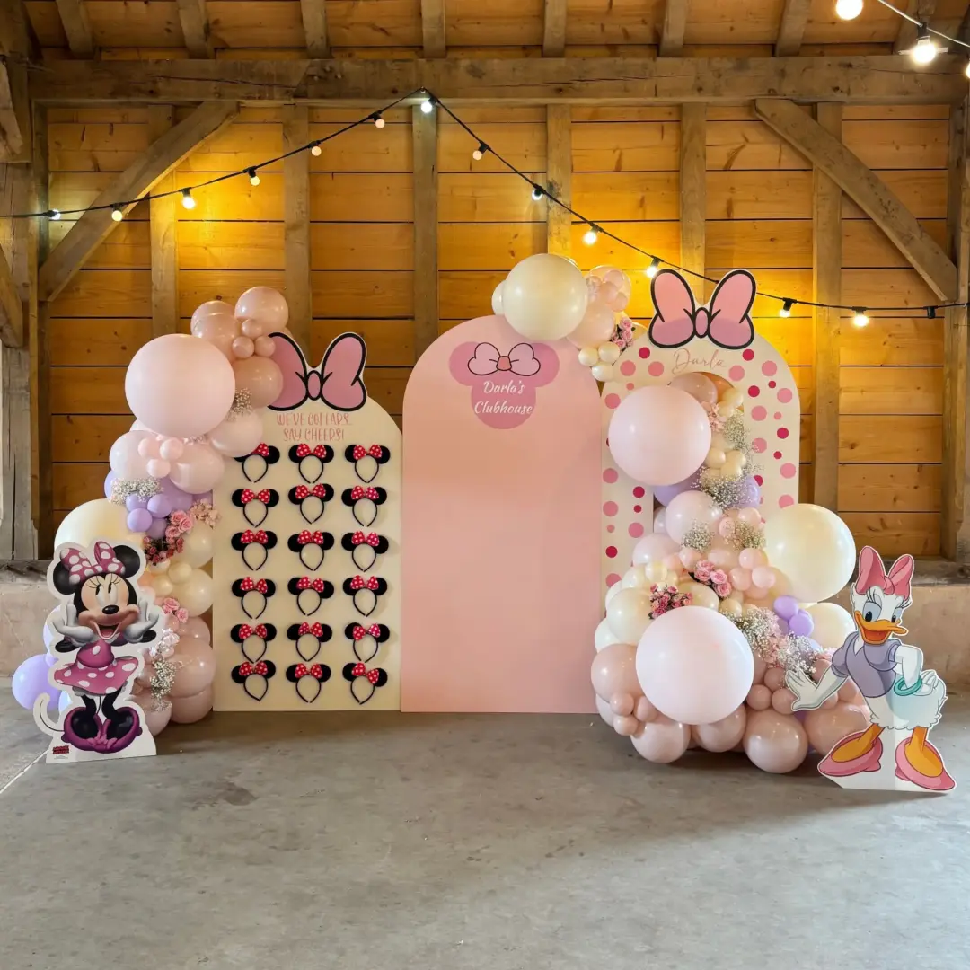 Pink mouse-themed party display with balloons, personalised boards and character cutouts